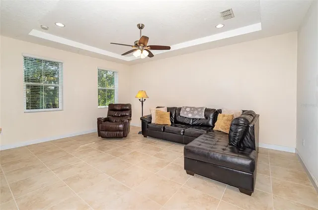 a living room with furniture and a ceiling fan
