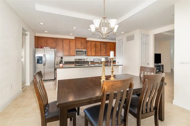 a view of a dining room with furniture a kitchen and chandelier
