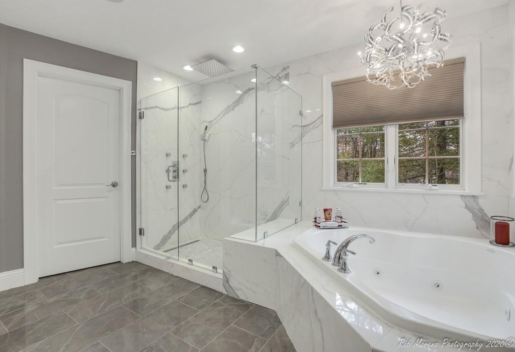 13 Pollock Drive Middleton, MA 01949 - Photo 25 of 42 a bathroom with a tub a sink a large mirror and a shower
