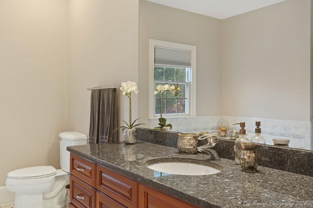 13 Pollock Drive Middleton, MA 01949 - Photo 35 of 42 a bathroom with a granite countertop sink a toilet and a mirror