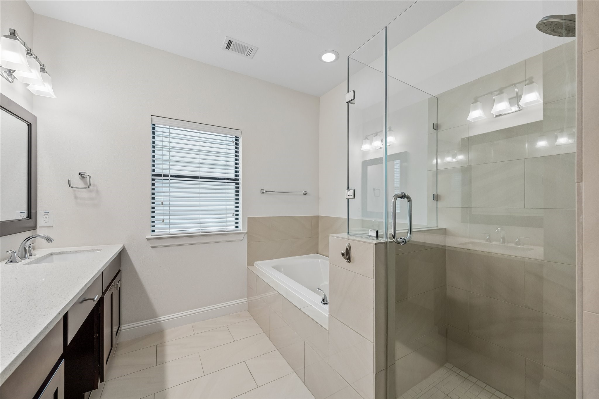 734 West 20th Street, Unit A Houston, TX 77008 - Photo 13 of 23 Primary bath features a soaking tub & oversized glass-enclosed shower w/ tile surround, complemented by neutral finishes & great natural light for a bright, relaxing feel.