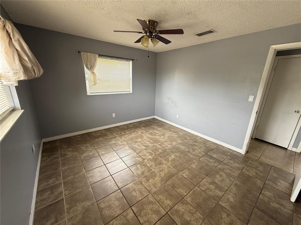9275 Chase Street Spring Hill, FL 34606 - Photo 12 of 29 an empty room with windows and fan