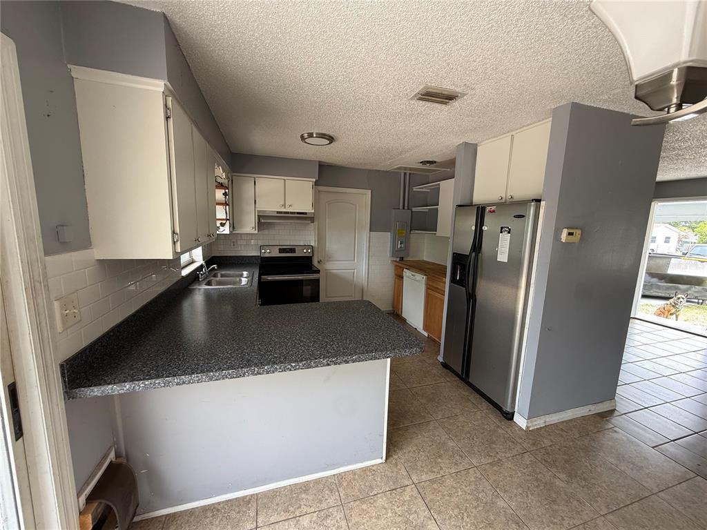 9275 Chase Street Spring Hill, FL 34606 - Photo 2 of 29 a kitchen with stainless steel appliances granite countertop a refrigerator a stove and a sink