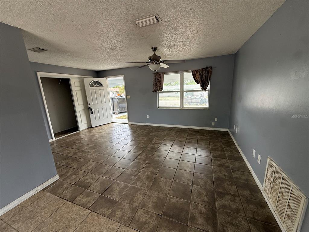 9275 Chase Street Spring Hill, FL 34606 - Photo 3 of 29 an empty room with windows and fireplace