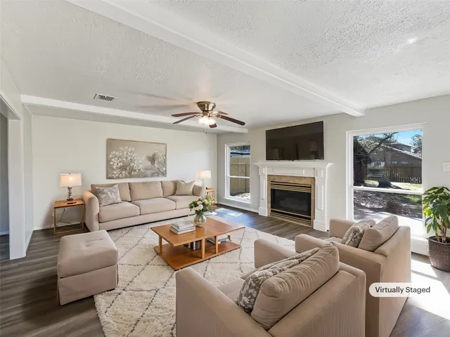 a living room with furniture a flat screen tv and a fireplace