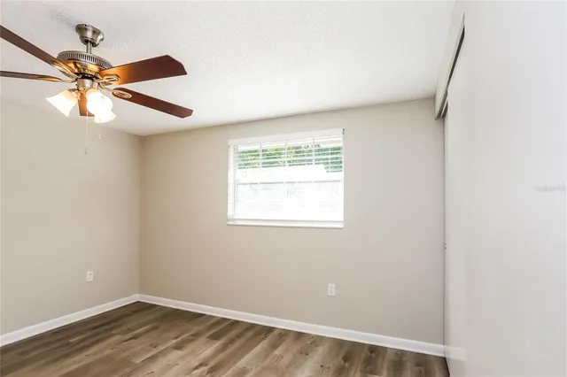 an empty room with a window and a fan