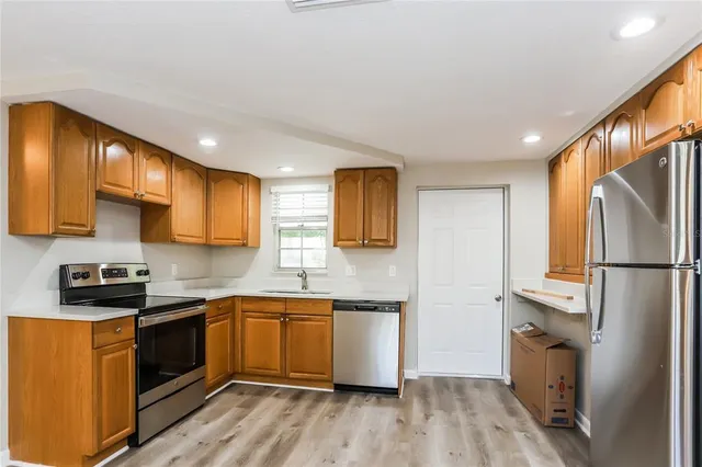 a kitchen with a sink a refrigerator a microwave and cabinets
