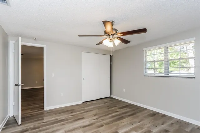 an empty room with wooden floor and window