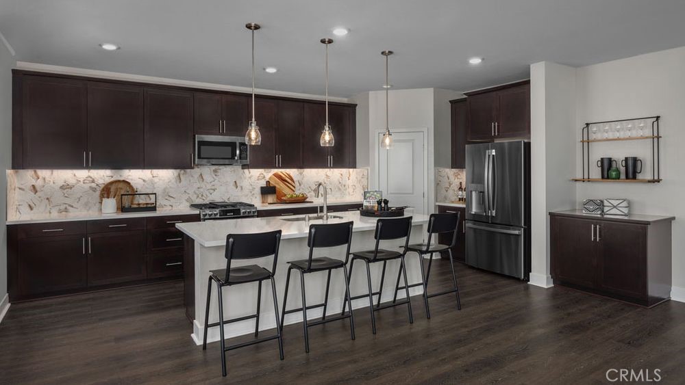 9552 Glenmore Frst Drive Riverside, CA 92508 - Photo 5 of 17 a kitchen with kitchen island granite countertop a sink cabinets and stainless steel appliances