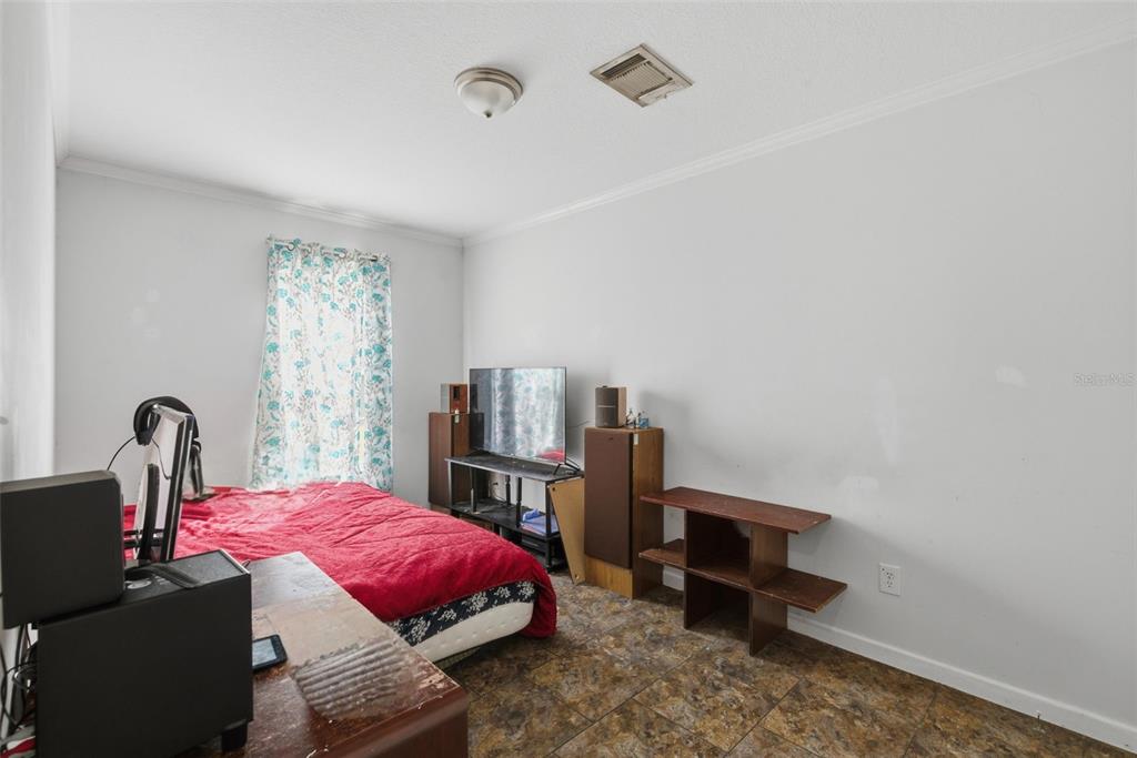 5022 Carol Drive Wesley Chapel, FL 33543 - Photo 11 of 25 a bedroom with a bed and a table with potted plants