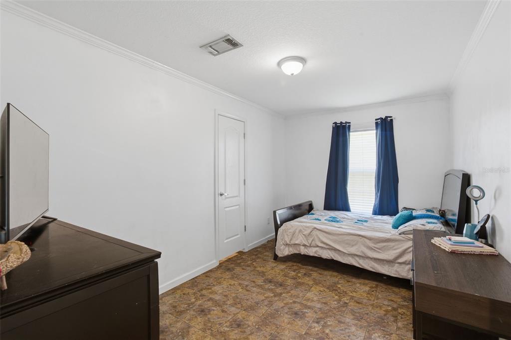 5022 Carol Drive Wesley Chapel, FL 33543 - Photo 10 of 25 a bedroom with a bed and a flat screen tv