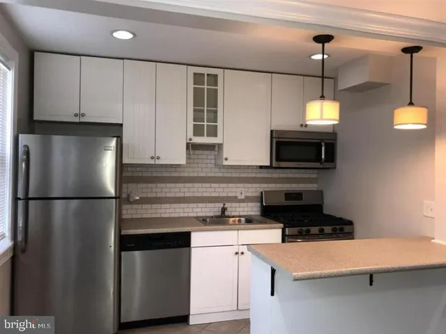 a kitchen with stainless steel appliances a refrigerator a stove a microwave and sink