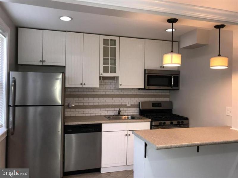 a kitchen with stainless steel appliances a refrigerator a stove a microwave and sink