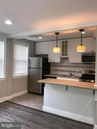 a kitchen with stainless steel appliances granite countertop a refrigerator a sink and a stove