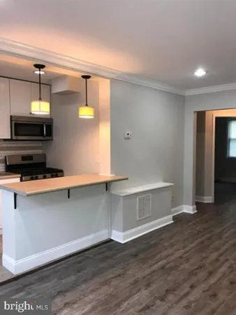 a view of kitchen with wooden floor and electronic appliances