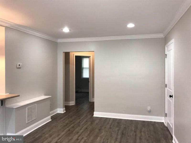 1106 Gleneagle Road, Unit 2 Baltimore, MD 21239 - Photo 4 of 10 a view of an empty room with wooden floor and a window