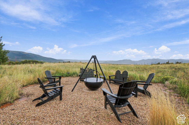5936 Triple Crown Trail Oakley, UT 84055 - Photo 36 of 57 Gravel patio area featuring a built-in fire pit, surrounded by open fields and distant mountains