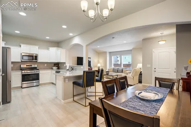 a large kitchen with kitchen island a stove a sink a dining table and chairs