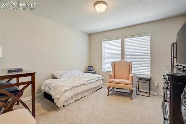 a bedroom with a bed chair and a desk