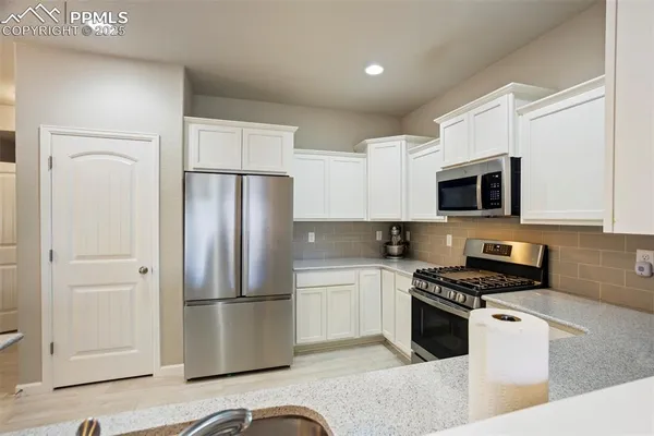 a kitchen with stainless steel appliances granite countertop a refrigerator stove and microwave