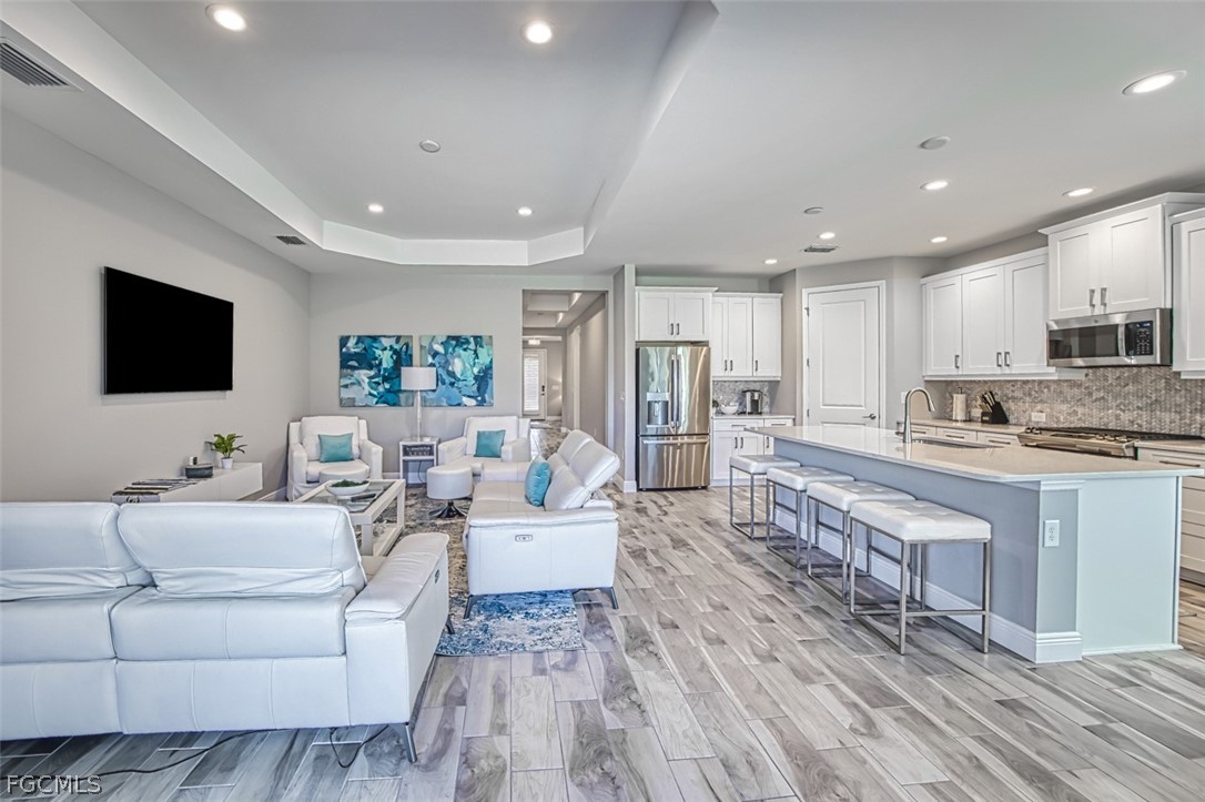 2925 Willow Ridge Court Fort Myers, FL 33905 - Photo 15 of 50 a living room with stainless steel appliances furniture a flat screen tv and a view of kitchen