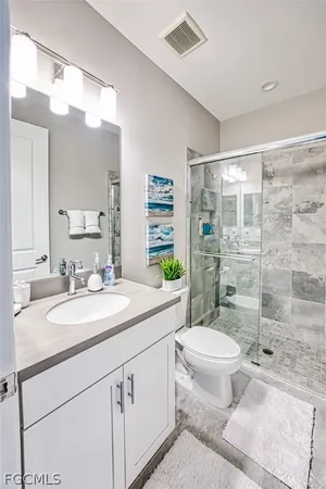 a bathroom with a granite countertop sink mirror vanity and toilet