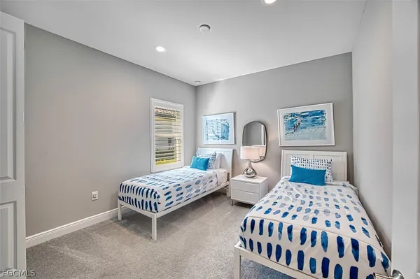 a bedroom with two beds and a window