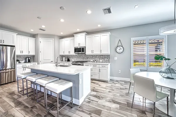 a kitchen with stainless steel appliances kitchen island granite countertop a sink and cabinets