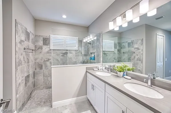 a bathroom with a granite countertop sink a large mirror and a shower