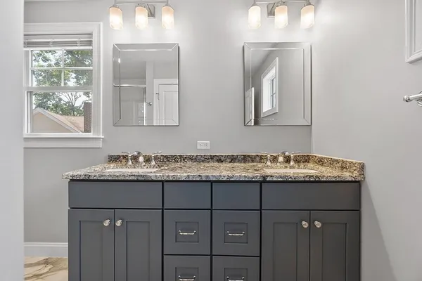 a bathroom with a granite countertop sink mirror and shower
