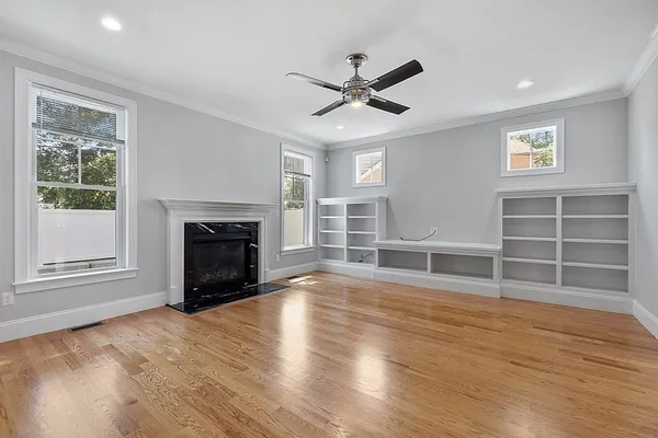 a kitchen with granite countertop a stove top oven a sink dishwasher a refrigerator and a dining table with wooden floor