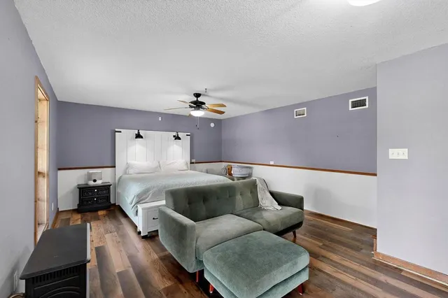 a bedroom with a bed a window and a flat screen tv