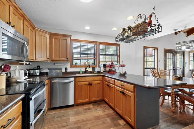 a kitchen with stainless steel appliances granite countertop a sink a stove and a refrigerator