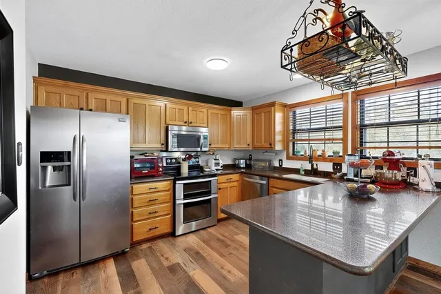 a kitchen with granite countertop a refrigerator stove top oven and sink