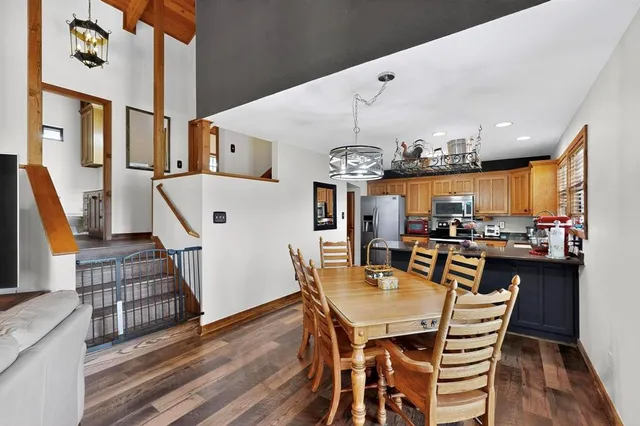 a view of a dining room with furniture a chandelier and wooden floor
