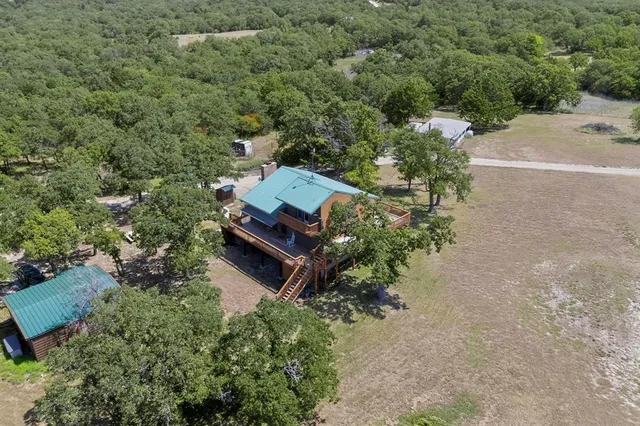 an aerial view of a house with a yard basket ball court and outdoor seating