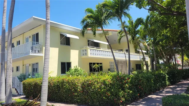 a front view of a multi story residential apartment building with a garden