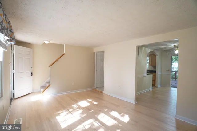 a view of a big room with wooden floor and windows