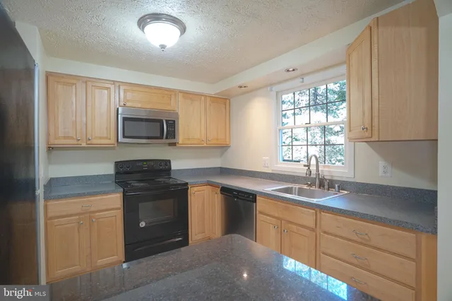 a kitchen with sink a microwave and cabinets