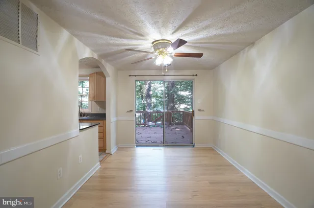 a view of a hallway with a chandelier fan and wooden floor