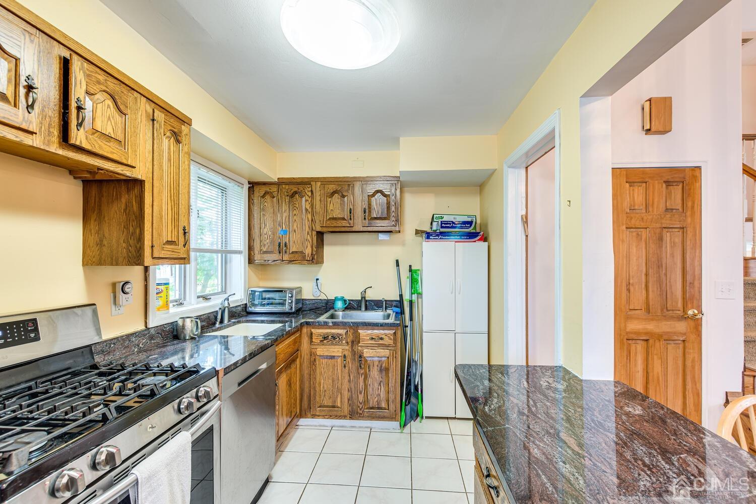 41 Partch Place Edison, NJ 08817 - Photo 14 of 28 a kitchen with stainless steel appliances granite countertop a stove and a refrigerator