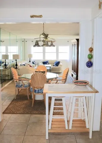 a view of a dining room with furniture a kitchen and chandelier