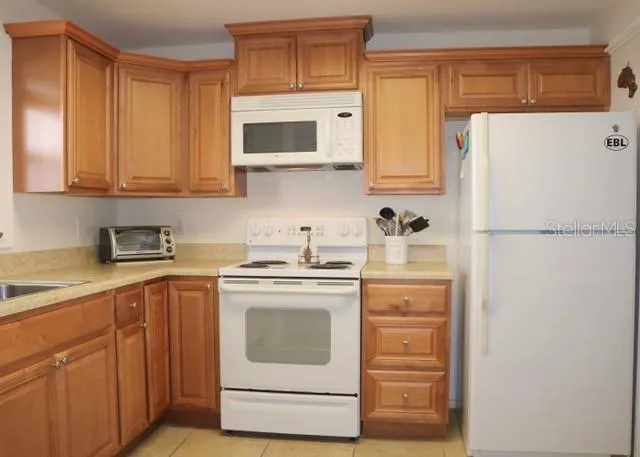 a kitchen with a refrigerator sink stove and cabinets