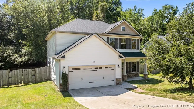 a view of a house with a yard and large tree