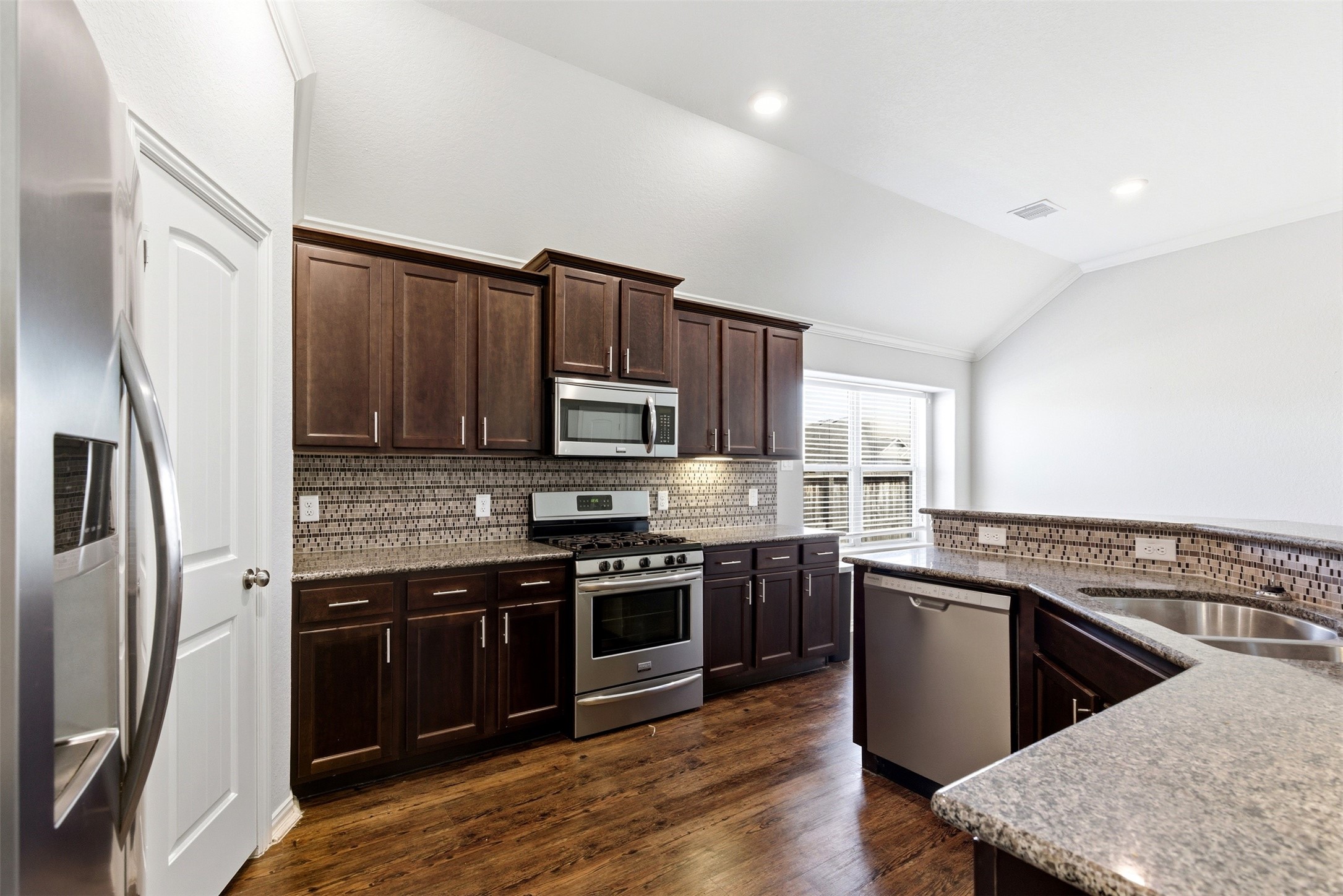 4507 Barnstone Ridge Lane Rosharon, TX 77583 - Photo 6 of 23 a kitchen with stainless steel appliances granite countertop a stove top oven a sink and dishwasher a refrigerator with wooden floor