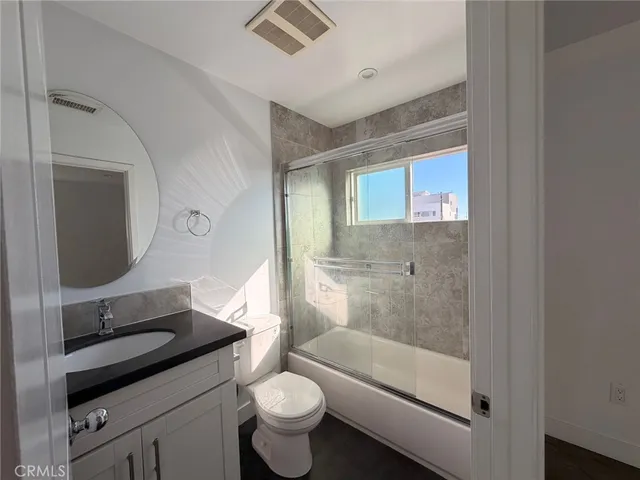 a bathroom with a granite countertop sink toilet and shower