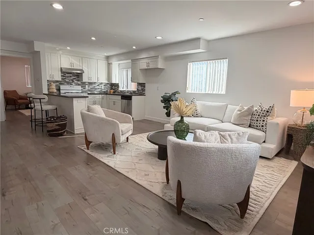 a living room with furniture and kitchen view