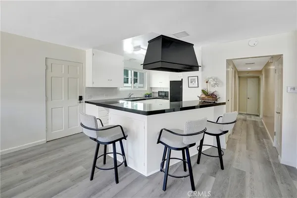 a kitchen with stainless steel appliances a table and chairs in it