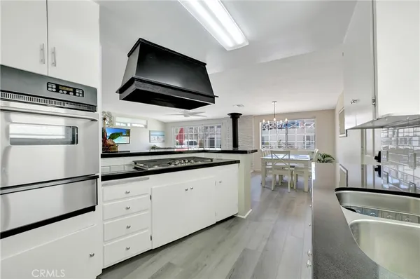a kitchen with granite countertop a sink a stove and cabinets