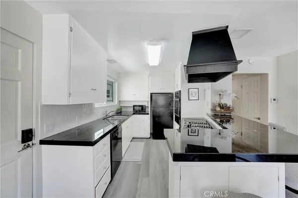 a kitchen with stainless steel appliances a sink a stove a refrigerator and cabinets